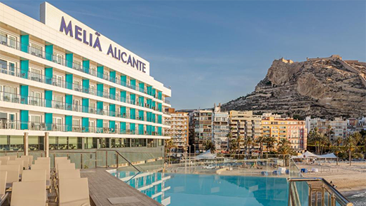 Melia Alicante hotel with an infinity pool overlooking the city and a mountain.