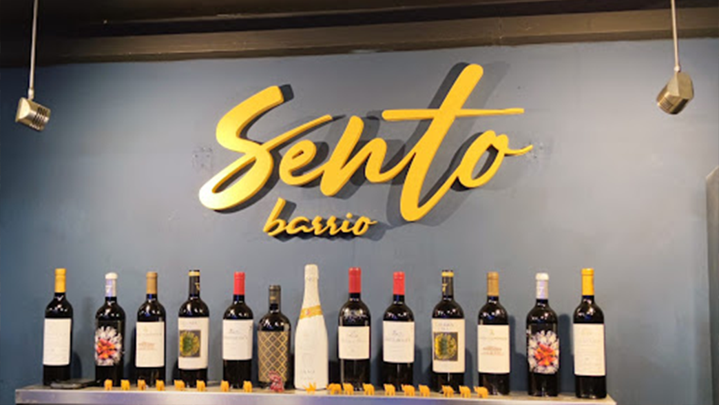 Wine display with "Sento Barrio" sign on the wall.