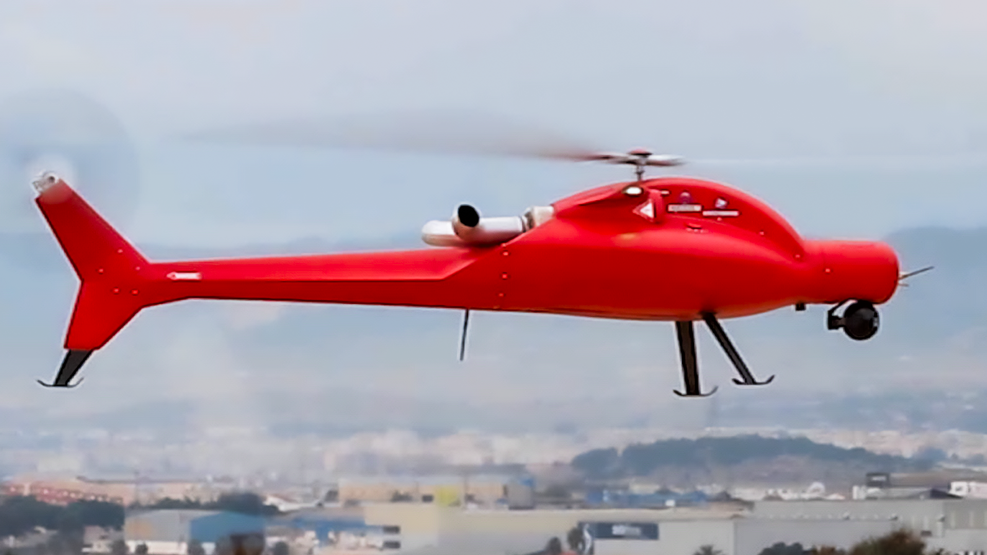 Tactical helicopter drone in flight, featuring a sleek red design, optimized for surveillance and harsh environments.